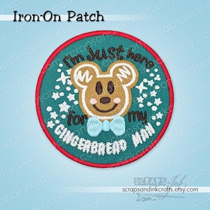 May include: Round iron-on patch with a gingerbread man design. The patch features a brown gingerbread man with a blue bow tie, surrounded by text that reads "I'm just here for my gingerbread". The patch has a red border and a teal background.