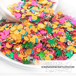 May include: A white bowl filled with colorful resin flatback embellishments. The embellishments are shaped like pineapples, palm trees, flowers, and Mickey Mouse heads. The bowl is sitting on a white surface.  Scraps & Ink, Scrapsandinkcrafts.etsy.com