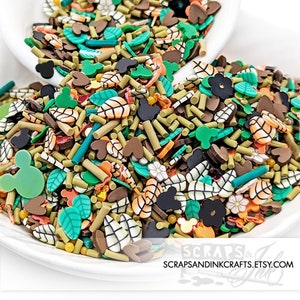 May include: A bowl filled with colorful sprinkles in various shapes, including Mickey Mouse heads, leaves, hearts, and sticks. The sprinkles are a mix of brown, green, orange, and white.