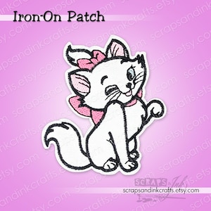 Pode incluir: Um patch bordado para passar a ferro com um gato branco de desenho animado com um laço rosa e uma expressão piscando. O patch tem um contorno preto e o texto "Iron-On Patch" no topo. O fundo é rosa claro.
