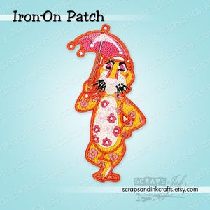May include: Embroidered iron-on patch featuring a cartoon tiger holding a pink umbrella. The tiger is yellow and orange with pink flower accents. The patch has the text "Iron-On Patch" at the top.