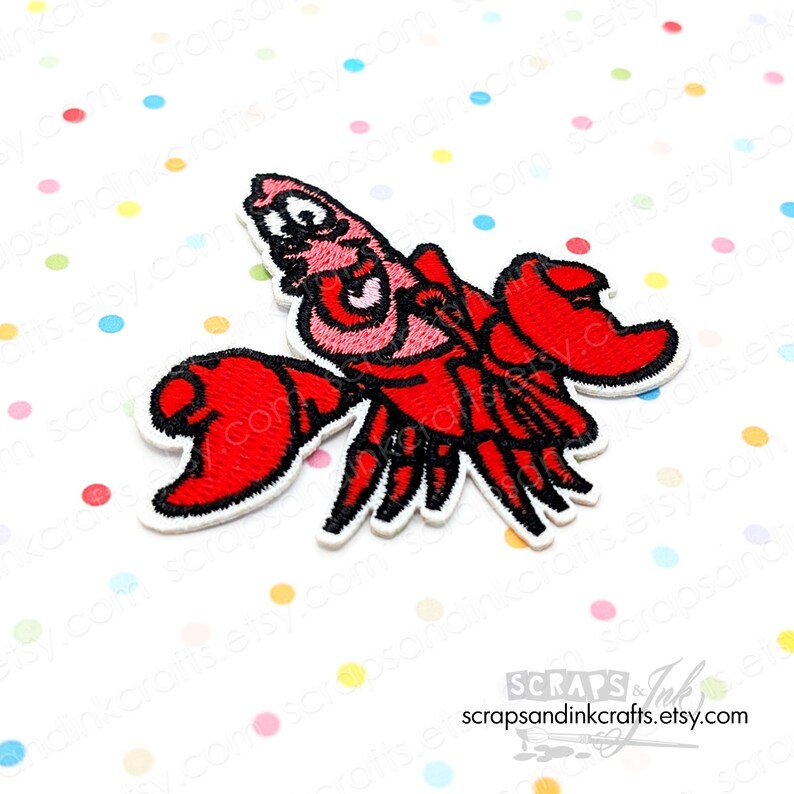 May include: Embroidered red lobster patch with black detailing and a white border. The lobster has large claws and a detailed face. The patch is on a white background with colorful polka dots. The Etsy shop name is visible in the bottom right corner.