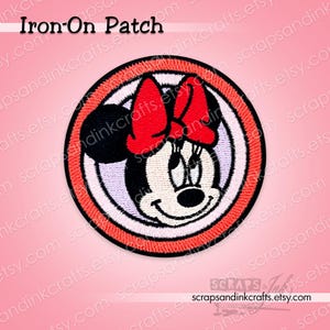 Può includere: Toppa rotonda termoadesiva con Minnie Mouse, fiocco rosso e volto sorridente. La toppa ha un bordo a righe rosse e bianche e il testo "Iron-On Patch" in alto. Il nome del negozio Etsy è visibile in basso.