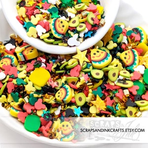 Könnte beinhalten: Eine bunte Mischung aus Harzstreuseln in Form von Avocados, Tacos und Sternen. Die Streusel befinden sich in einer weißen Schüssel und sind auf einer weißen Oberfläche verstreut. Die Streusel sind perfekt, um jedem Bastelprojekt eine lustige und festliche Note zu verleihen.