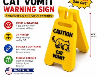 May include: A bright yellow, A-frame caution sign measuring 4.5 inches in height. The sign features a black graphic of a cat and the text CAUTION CAT VOMIT. The object is a freestanding, foldable plastic warning marker designed for indoor use.