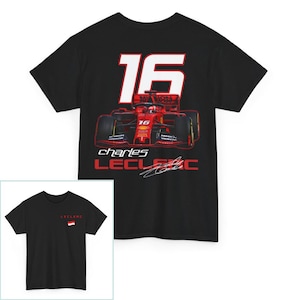 May include: Black t-shirt with a red and white Formula 1 race car graphic. The car has the number 16 on it. The text "charles LECLEC" is below the car with a signature.