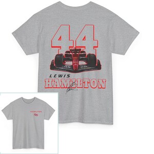 K&ouml;nnte beinhalten: Ein graues T-Shirt mit einem roten und wei&szlig;en Bild eines Rennwagens und der Nummer 44. Der Text "Lewis Hamilton" ist unter dem Auto aufgedruckt.