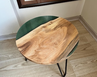 May include: A round wooden side table with a green epoxy resin inlay. The table has a black metal frame with hairpin legs.