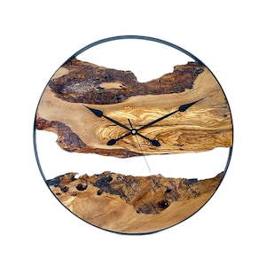 Puede incluir: Un reloj de pared redondo de madera con un marco de metal negro. La esfera del reloj está hecha de una rebanada de madera natural con un patrón de veta único. Las manecillas del reloj son negras.
