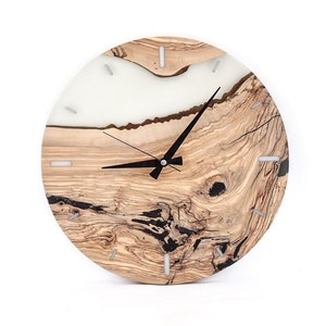 Könnte beinhalten: Eine runde Wanduhr aus Holz mit einer weißen Harzeinlage. Das Zifferblatt hat schwarze Zeiger und weiße römische Ziffern.