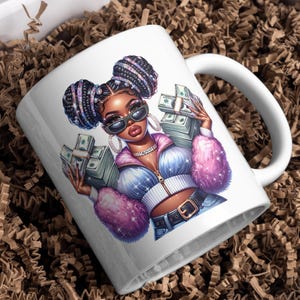 May include: White ceramic mug with a colorful illustration of a woman with braids holding stacks of money. The woman is wearing a pink and blue jacket and jeans.