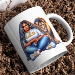 May include: White ceramic mug with a vibrant illustration of a woman with long braids, wearing a white t-shirt with "LEO" in gold lettering, and blue jeans. A lion is behind her. The mug is in a box with brown packing material.