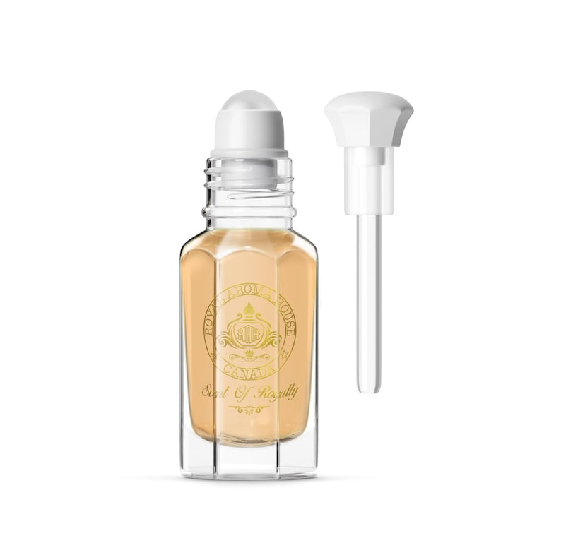 May include: A clear glass perfume bottle with a white rollerball top and a separate white pump. The bottle contains a light beige liquid and features gold lettering and a crest. The text on the bottle reads "ROYAL AROMA HOUSE CANADA" and "Scent Of Royalty".