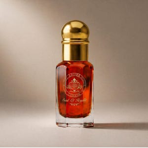 Peut inclure: Flacon de parfum avec un bouchon doré et un corps clair et rectangulaire. Le flacon contient un liquide brun rougeâtre et présente des lettres dorées et un écusson. Le texte sur le flacon indique "Aroma House Canada" et "Scent of Royalty."
