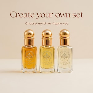 以下が含まれることがあります： ゴールドのキャップとScent of Royaltyのラベルが付いた3本のガラス製香水瓶が並んでいます。ボトルの上部にはCreate your own setとChoose any three fragrancesというテキストがあり、ボトルの中には様々な琥珀色の液体が入っています。
