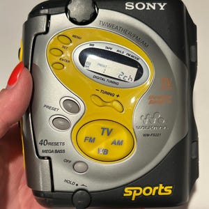 May include: A silver and black Sony Walkman WM-FS221 with yellow accents. Features include TV, FM, AM, and WB radio functions, digital tuning, and 40 presets. The word "sports" is printed in yellow.
