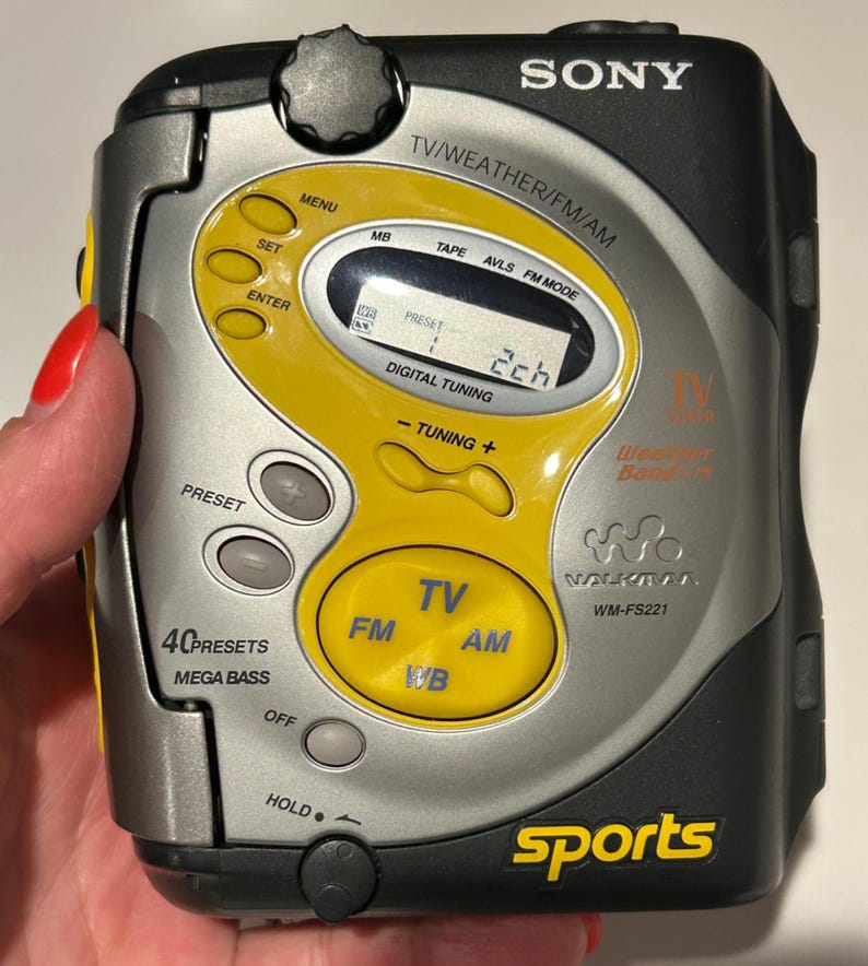 May include: A silver and black Sony Walkman WM-FS221 with yellow accents. Features include TV, FM, AM, and WB radio functions, digital tuning, and 40 presets. The word "sports" is printed in yellow.