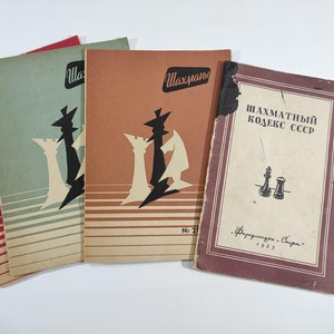 Puede incluir: Tres libros de bolsillo vintage con portadas de temática de ajedrez. Los libros se titulan "Шахматы" y "Шахматный Кодекс СССР".