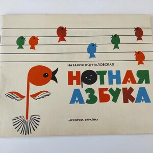 May include: A vintage children's book cover with a red bird illustration and the title "Нотная азбука" (Musical Alphabet) in colorful letters. The book is by Natalia Konchalovskaya and features a musical staff with colorful birds.