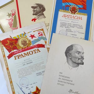 Könnte beinhalten: Eine Sammlung von Vintage-Sowjet-Propagandaplakaten mit roten Sternen, Flaggen und Porträts von Lenin und Stalin. Die Poster sind auf Papier gedruckt und haben einen verblassten, gealterten Look. Der Text auf den Postern enthält die Wörter "GRAMOTA" und "DIPLOM".