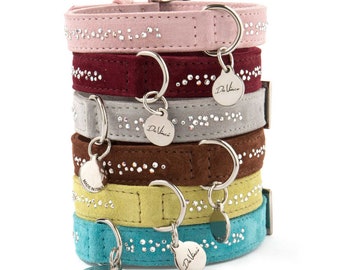 May include: A stack of six dog collars in various colors, including pink, burgundy, gray, brown, yellow, and blue. Each collar is adorned with a line of sparkling rhinestones and features a silver charm with the brand name "Da Vinci".