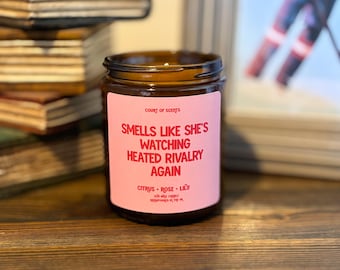 Ça sent comme si elle revoyait une rivalité passionnée : bougie parfumée aux agrumes, à la rose et au lys, bougie livresque