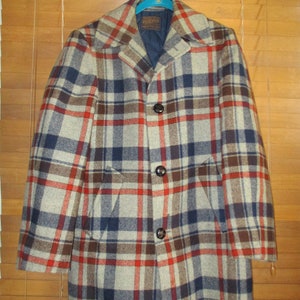 May include: A plaid wool coat with a brown, red, and blue pattern. The coat has a button closure and two pockets.