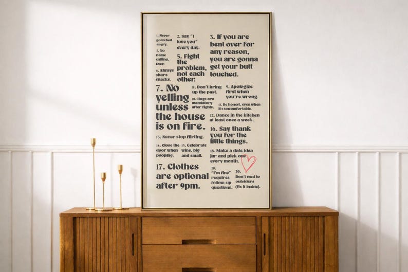Puede incluir: Una impresi&oacute;n enmarcada con un fondo beige y texto negro. El texto enumera reglas para una relaci&oacute;n, incluyendo "Di 'Te amo' todos los d&iacute;as" y "No grites a menos que la casa est&eacute; en llamas". Un coraz&oacute;n rojo est&aacute; dibujado en la impresi&oacute;n.