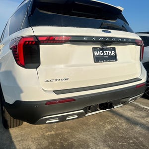 May include: White Ford Explorer SUV with a black rear bumper and a "BIG STAR Ford" dealership license plate. The vehicle has a "ACTIVE" badge on the rear bumper.