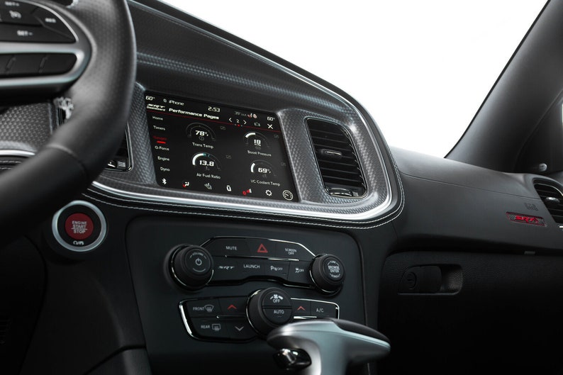 May include: A black car interior with a digital display showing performance data, including engine temperature, air fuel ratio, and coolant temperature. The display is labeled "Performance Pages".
