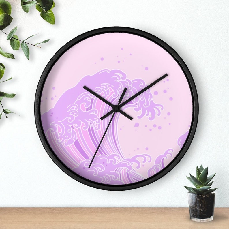 May include: A pink and purple wave design clock with black hands and a black frame.