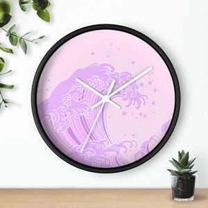 May include: A pink and white clock with a wave design. The clock has a black frame and white hands.