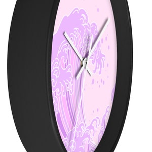 May include: A black framed clock with a pink and white wave design. The wave is stylized and has a Japanese aesthetic.