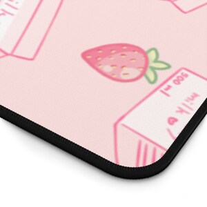 Peut inclure: Tapis de souris rose et blanc avec un motif r&eacute;p&eacute;t&eacute; de cartons de lait et de fraises. Les cartons de lait portent l'inscription "Lait 500 ml".