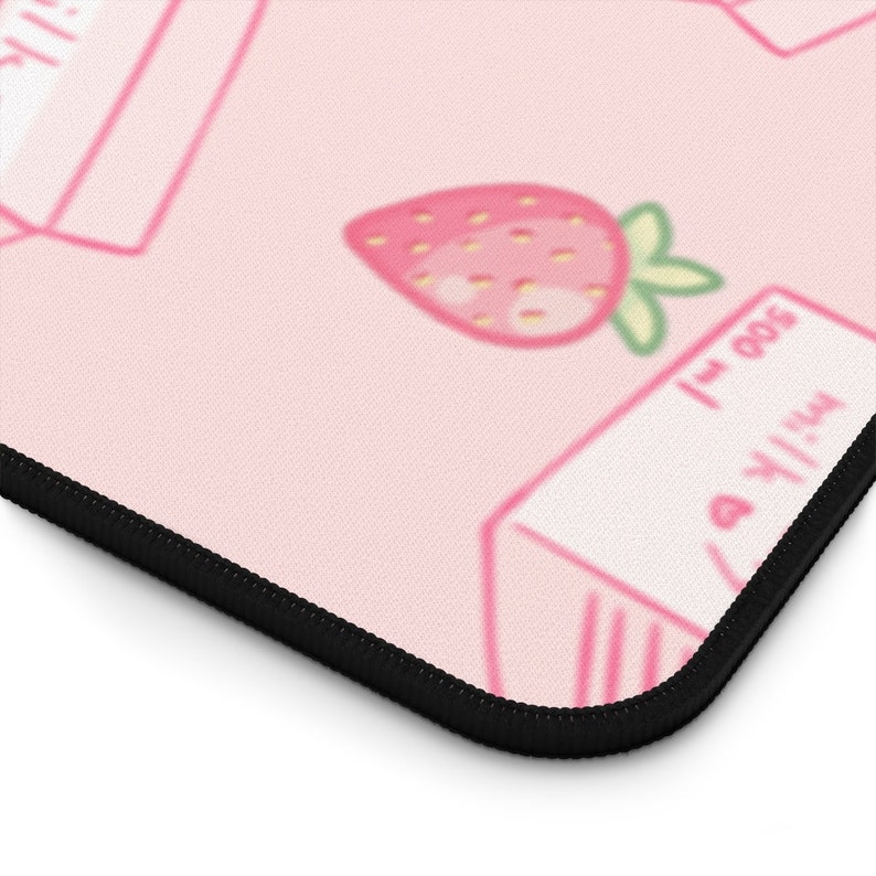 Peut inclure: Tapis de souris rose et blanc avec un motif r&eacute;p&eacute;t&eacute; de cartons de lait et de fraises. Les cartons de lait portent l'inscription "Lait 500 ml".