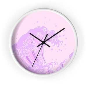 May include: A white wall clock with a pink background and a purple wave design. The wave is stylized and has a traditional Japanese look. The clock hands are black.
