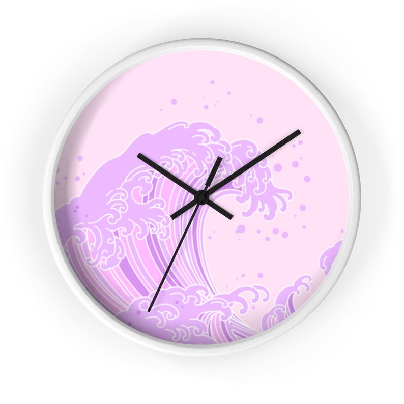 May include: A white wall clock with a pink background and a purple wave design. The wave is stylized and has a traditional Japanese look. The clock hands are black.