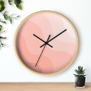 May include: A pink and white abstract wave design wall clock with black hands. The clock has a wooden frame.