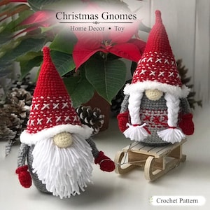 May include: Two handmade crochet gnomes featuring red pointed hats with white cross-stitch patterns, grey bodies, and red mittens. One gnome has a long white yarn beard, while the other has white yarn braids. The text reads Christmas Gnomes Home Decor Toy and Crochet Pattern.