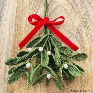 Può includere: Vischio verde all'uncinetto fatto a mano con perle bianche e un fiocco di nastro di velluto rosso. Le foglie sono dettagliate e le perle sono ben distanziate. Un oggetto decorativo festivo per le festività.