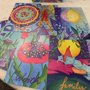 May include: Set of ten colorful cards with illustrations and text. The cards feature words like "Trust", "Balance", "Worth", and "Family".