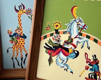 Two paint by number circus scenes framed