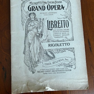 May include: An antique libretto cover for the Metropolitan Opera House's Grand Opera, featuring the opera "Rigoletto." The cover includes an illustration of a woman with a harp, the text "Libretto," and the price "35 CENTS."