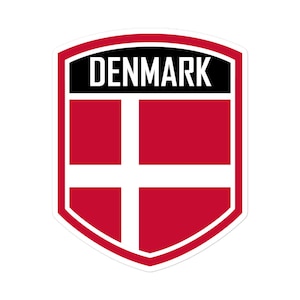 Könnte beinhalten: Ein roter Schild mit einem weißen Kreuz und dem Wort "DÄNEMARK" in schwarzen Buchstaben.