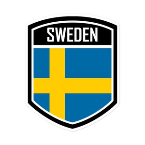 May include: A blue and yellow shield-shaped sticker with the word "SWEDEN" in black text at the top and the Swedish flag inside the shield.