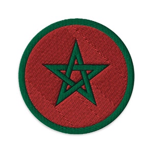 May include: A red circle with a green border and a green five-pointed star in the center. The star is a symbol of Morocco.