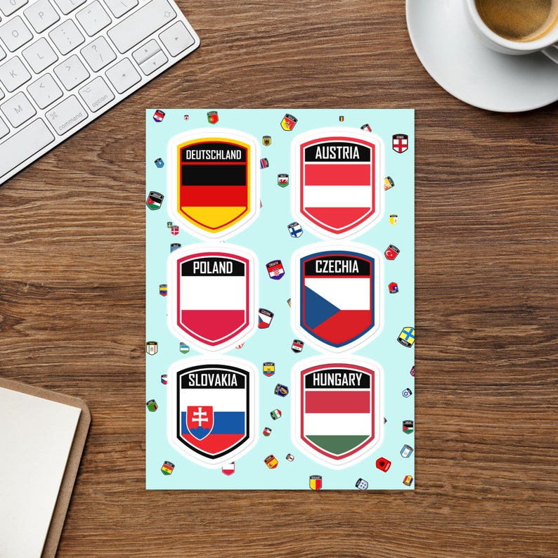 Puede incluir: Seis pegatinas de colores en forma de escudo con los nombres y las banderas de Alemania, Austria, Polonia, Rep&uacute;blica Checa, Eslovaquia y Hungr&iacute;a. Las pegatinas est&aacute;n sobre un fondo azul claro con un patr&oacute;n de banderas m&aacute;s peque&ntilde;as.