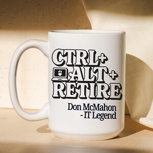 May include: White ceramic mug with a large handle. The mug features the text "CTRL+ALT+RETIRE" in black, along with a laptop and mouse icon. Below the text is "Don McMahon - IT Legend".