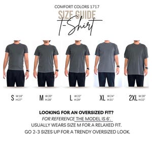 以下が含まれることがあります： Comfort Colors 1717 Tシャツのサイズガイド。画像には、Sから2XLまでのサイズのグレーのTシャツを着た5人のモデルが写っています。各サイズについて、幅45.7cmから66cm、高さ68.6cmから81.3cmの測定値が提供されています。