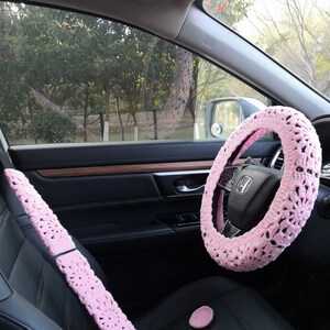 Puede incluir: Funda de volante de crochet rosa, fundas de cintur&oacute;n de seguridad y dos posavasos rosas para el interior de un coche.